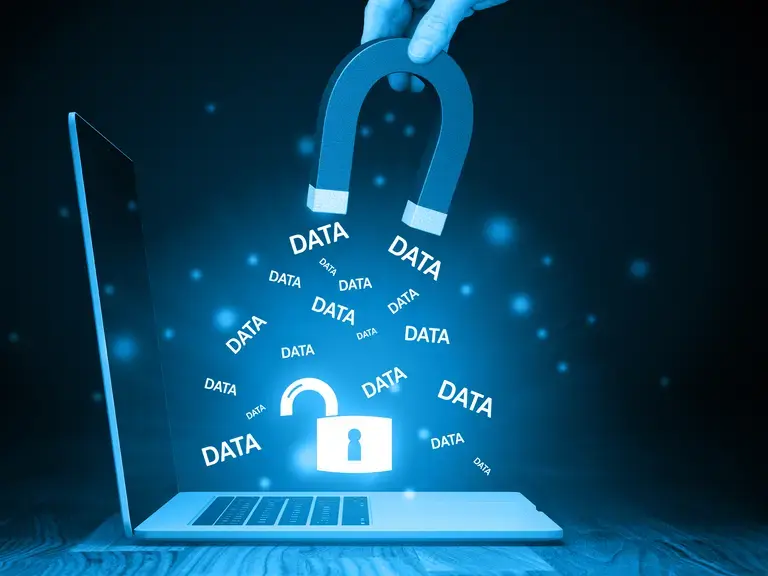 Symbolbild für Datenklau: Aus einem Laptop werden mit einem Magnet daten herausgezogen