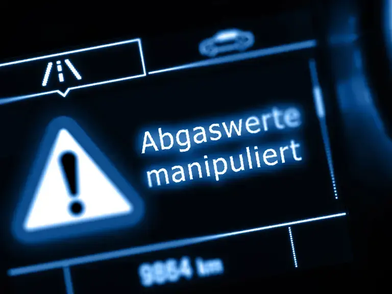 Displayanzeige eines Tachos auf dem steht: Abgaswerte manipuliert