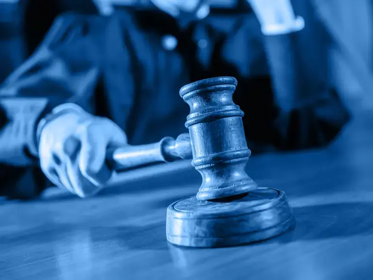 Ein Richter der mit dem Richterhammer ein Urteil verkündet.