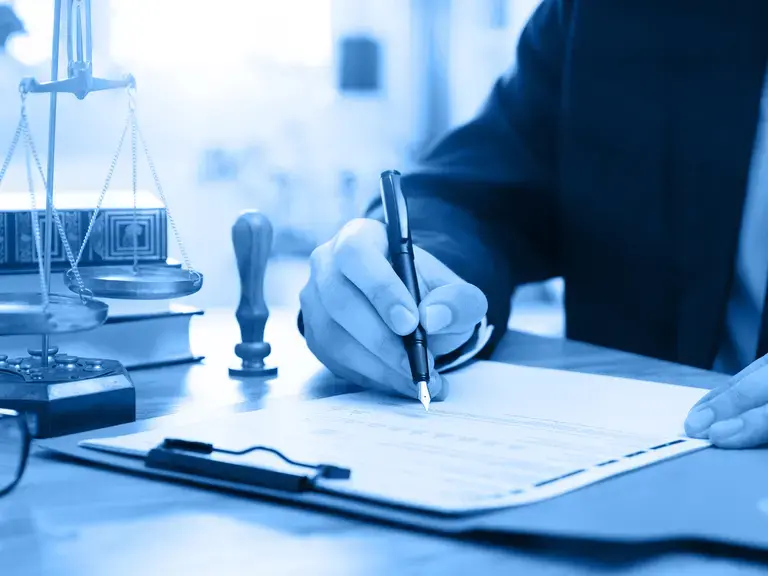 Ein Vertrag auf einem Klemmbrett der unterschrieben wird