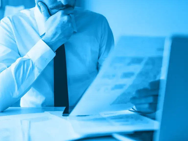 Ein Mann der seine Hand an den Mund gelegt hat und einen Ausdruck in der Hand hält