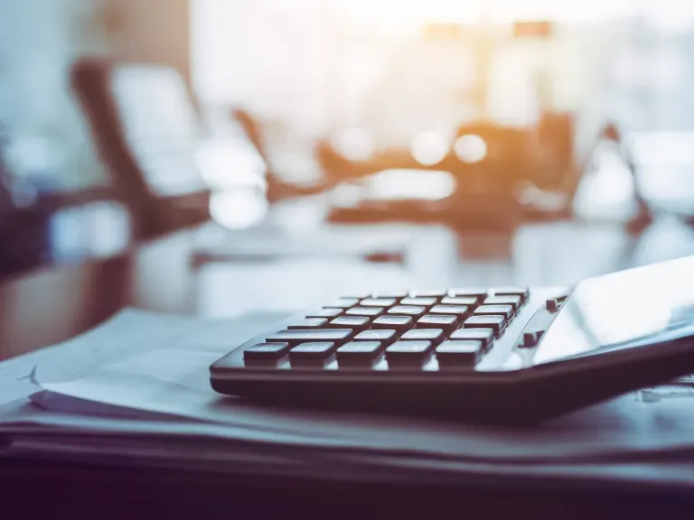 Ein Taschenrechner, der auf einem Tisch auf Papieren liegt