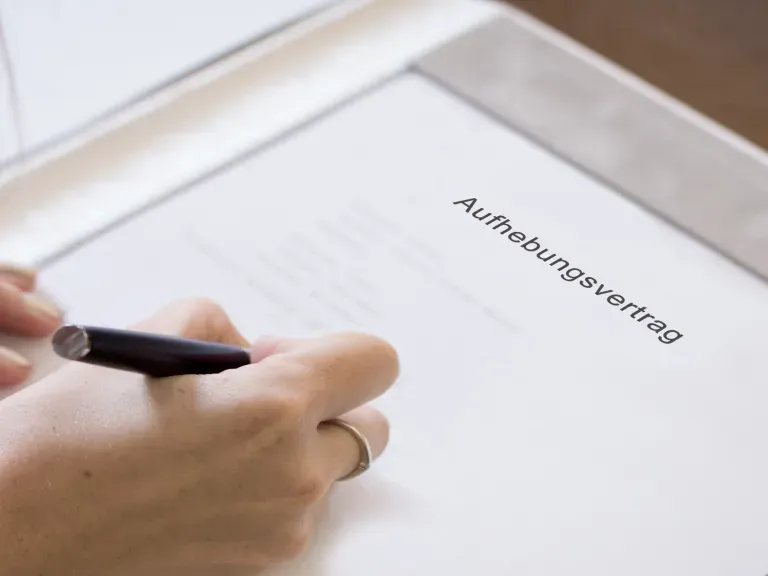 Aufhebungsvertrag, der von eine Hand unterschrieben wird
