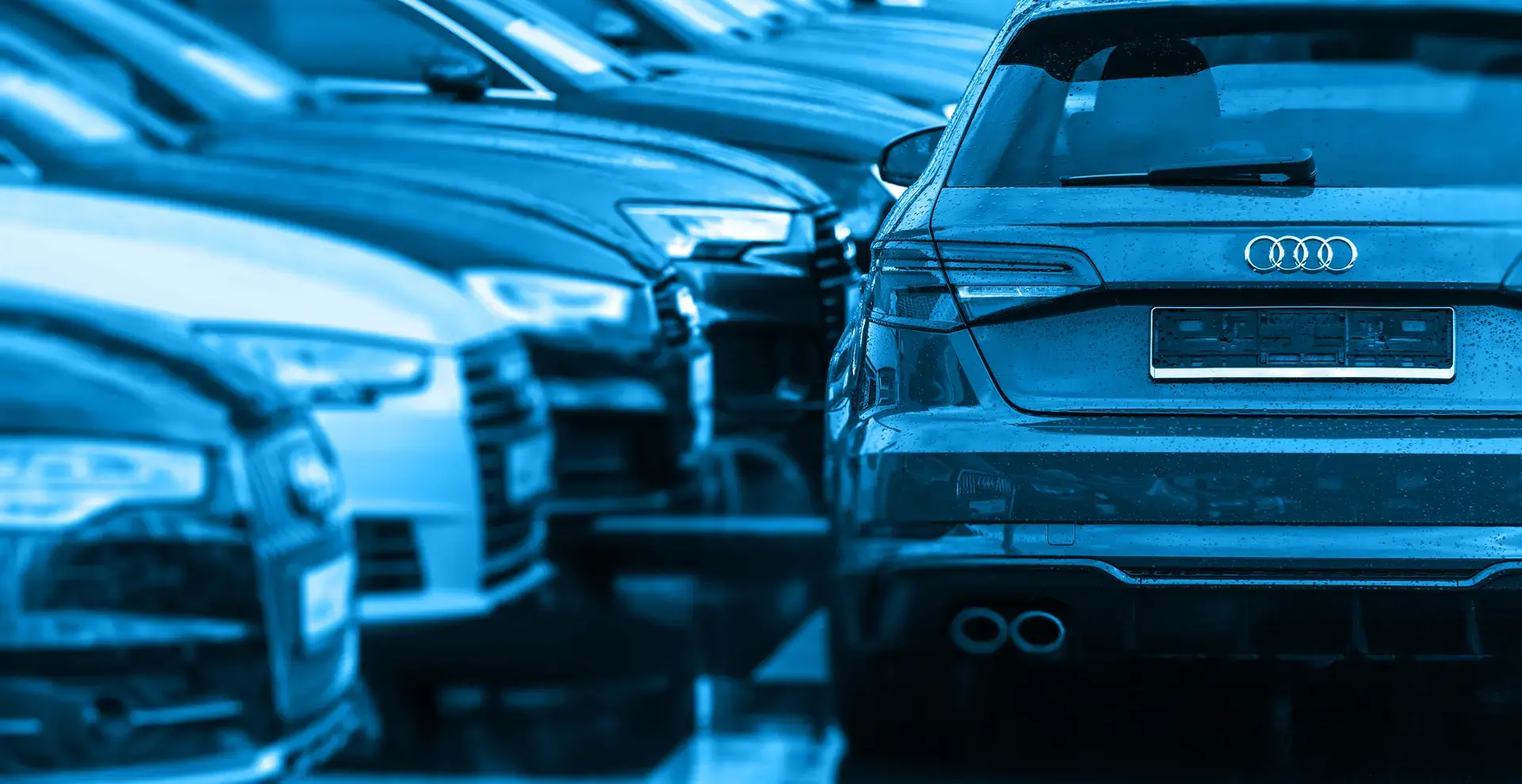 Eine Reihe geparkter Audis davon steht quer ein weiterer Audi