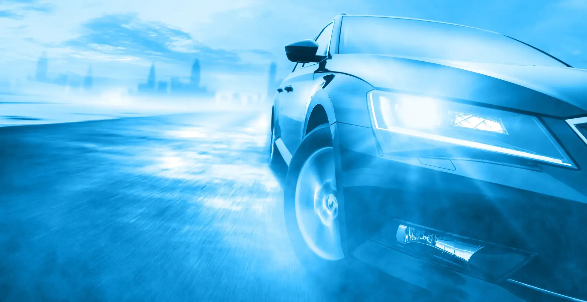 Teilausschnitt von der linken Frontseite eines Autos, das um eine Kurve fährt