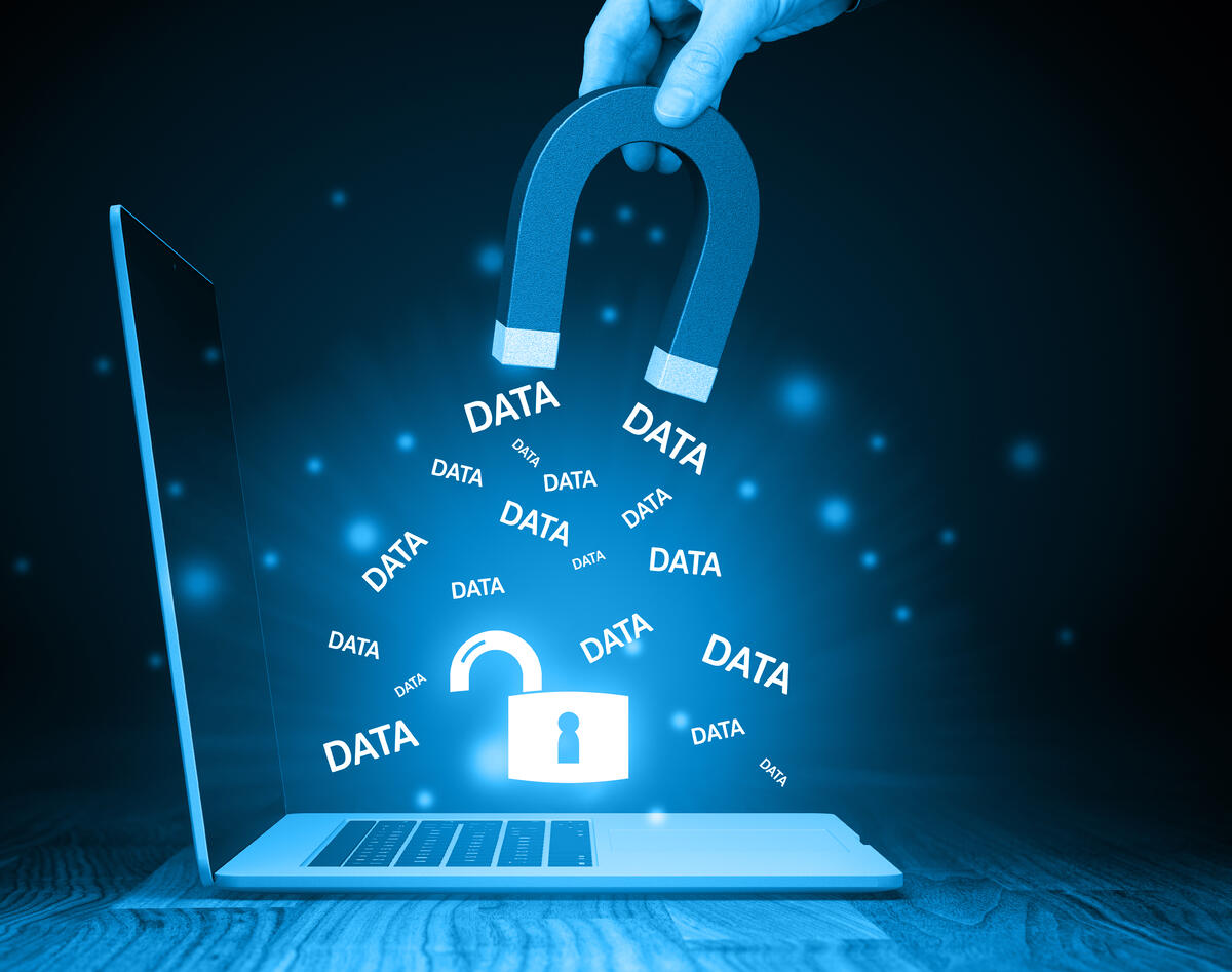 Symbolbild für Datenklau: Aus einem Laptop werden mit einem Magnet daten herausgezogen