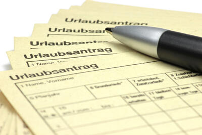 Stift der auf einem Urlaubsantrag liegt