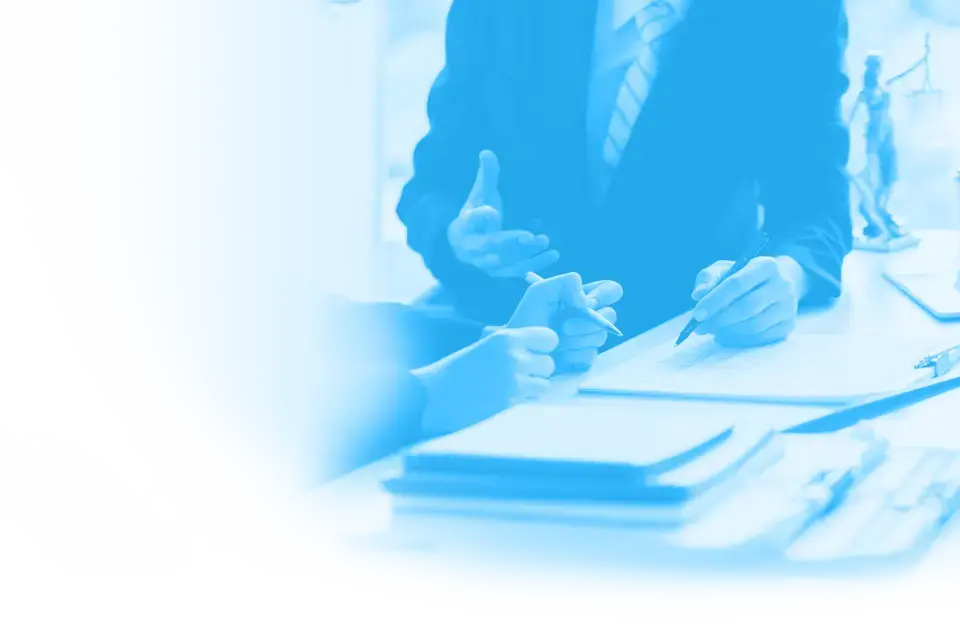 Papiere auf einem Tisch und Hände die etwas dazu erklären