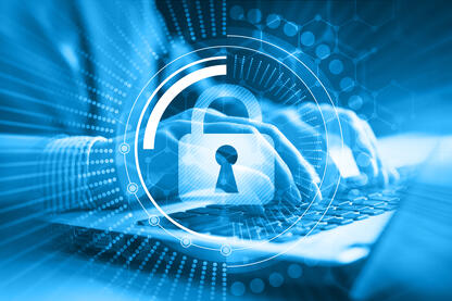 Ein digitales Bild im Hintergrund Hände, die ein Laptop bedienen, im Vordergrund ein digitales Schloss